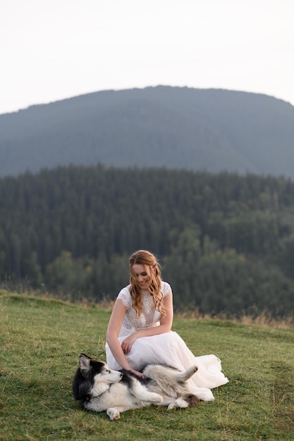 Hochzeitspaar mit Hund in den Bergen bei Sonnenuntergang romantischer Abend in den Bergen