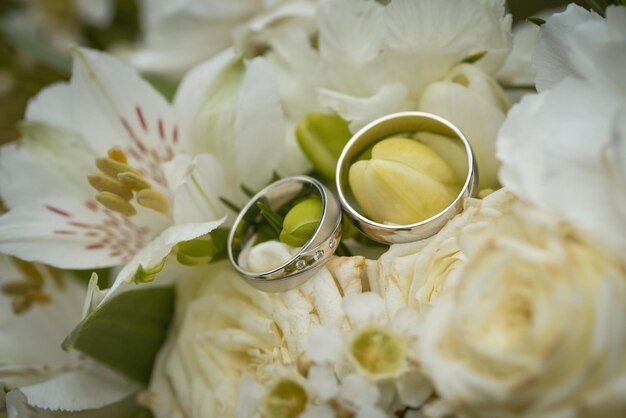 Hochzeitsringe auf einem Bouquet weißer Blumen