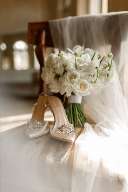 Hochzeitsschuhe und Brautbüchel auf einem Vintage-Stuhl