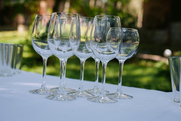 Hochzeitssektgläser stehen auf dem Tisch, auf einer weißen Tischdecke im Garten. Hochzeit.