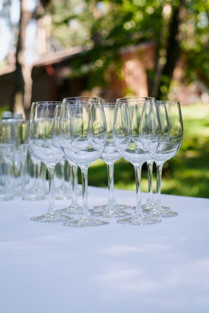 Hochzeitssektgläser stehen auf dem Tisch, auf einer weißen Tischdecke im Garten. Hochzeit.