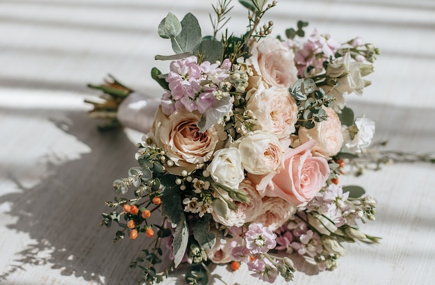 Foto hochzeitsstrauß aus pfingstrosenblumen auf dem boden des brautpaares