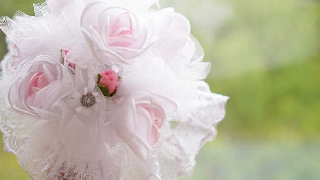 Hochzeitsstrauß aus weißen rosen auf einem verschwommenen grünen hintergrund