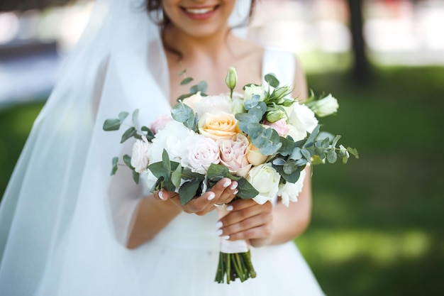 Hochzeitsstrauß in den Händen der Braut Stilvoller eleganter Brautstrauß Hochzeitstag Floristik