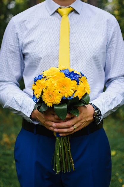 Foto hochzeitsstrauß in den händen des bräutigams