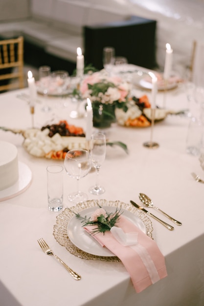 Hochzeitstafel Empfang goldener Teller unter weißem rosa Stofftuch rosa Blume mit Seidenband