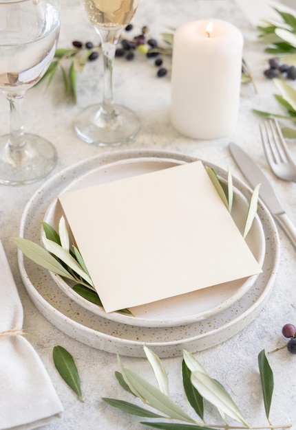 Hochzeitstafel mit einer mit Olivenzweigen verzierten Karte