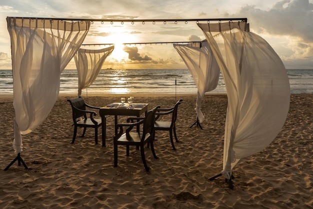 Foto hochzeitstisch am meeresstrand bei sonnenuntergang