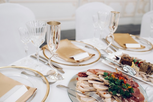 Hochzeitstischdekoration mit Blumen auf dem Tisch im Schloss, Tischdekoration zum Abendessen bei Kerzenschein. Abendessen mit Kerzen