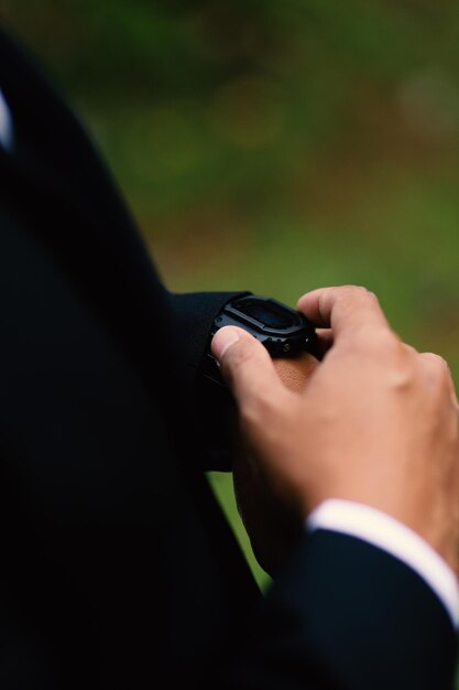 Hochzeitsvorbereitungen Herrenuhr in der Hand beim Aufräumen der Kleidung vor der Zeremonie