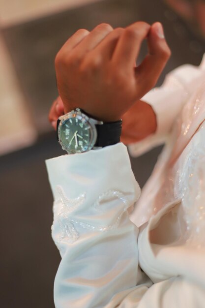 Hochzeitsvorbereitungen Herrenuhr in der Hand beim Aufräumen der Kleidung vor der Zeremonie