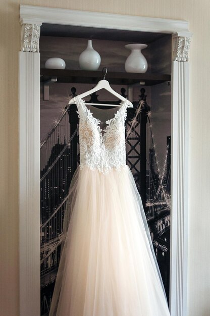 Hochzeitsweißes Brautkleid, das am Kleiderbügel hängt