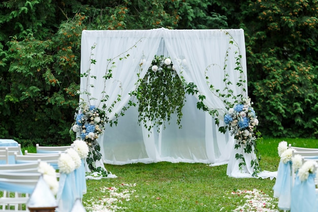 Hochzeitszeremonie Dekoration Bogenstühle Zeiger und viele Blumen im weißen und blauen Stil