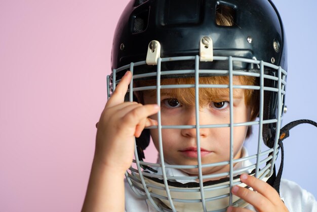 Hockey- oder Rugbyhelm Sportkindheit Zukünftiger Sportstar Sporterziehung und Karriere Junge süßes Kind trägt Hockeyhelm aus nächster Nähe Sicherheit und Schutz Schutzgitter im Gesicht Sportgeräte