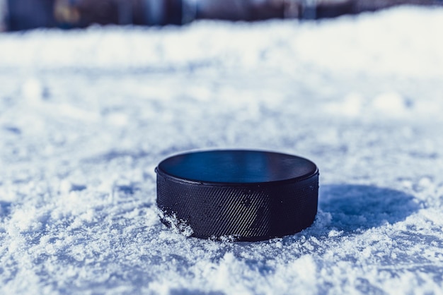 Hockeypuck liegt auf der Schneenahaufnahme