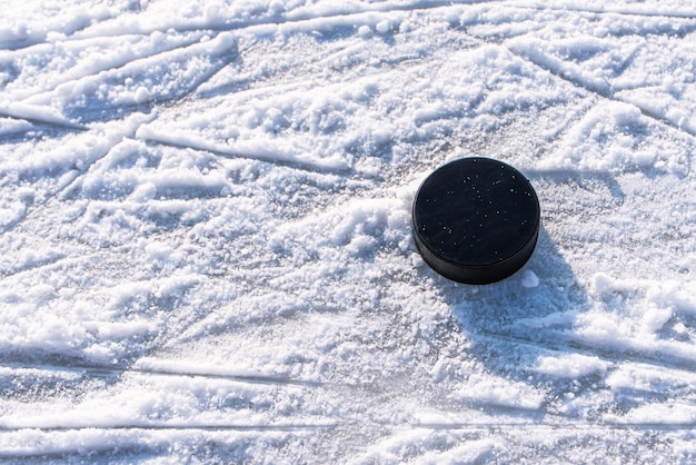 Hockeypuck liegt auf der Schneenahaufnahme