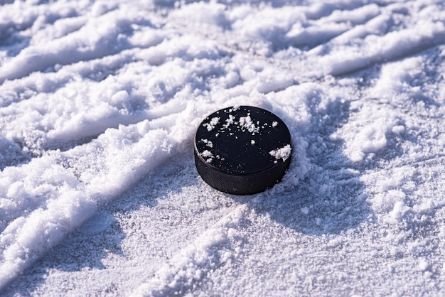 Hockeypuck liegt auf der Schneenahaufnahme