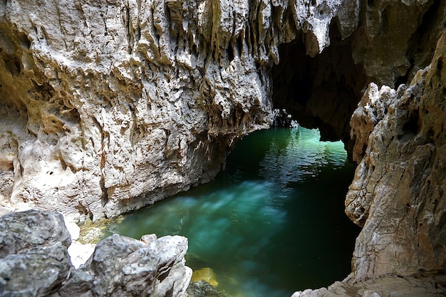 Höhle in Felsen mit Flusswasser gefüllt. Blendung auf der Steinoberfläche des Großsegels. Reflexion von Flüssigkeit an der Wand der Grotte