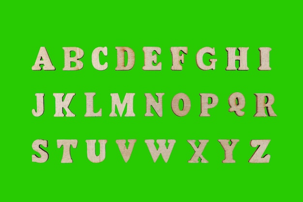 hölzerne Buchstaben des englischen Alphabets auf grünem Hintergrund
