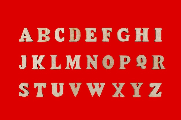 hölzerne Buchstaben des englischen Alphabets auf rotem Hintergrund