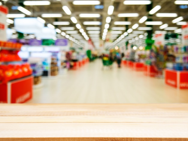 Hölzerne leere Tabelle vor unscharfem Supermarkt