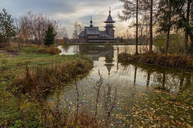 Hölzerne orthodoxe Verkündigungskirche und ihr Spiegelbild im See an einem Herbsttag. Region Moskau, Bezirk Sergiev Posad. Das Dorf Blagoveshheniye