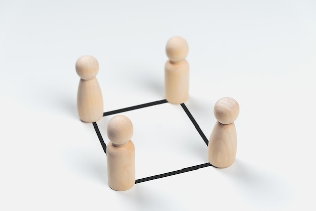 Hölzerne Peg-Puppen sind mit Linien auf weißem Hintergrund verbunden Teamwork-Führung
