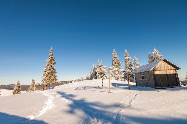 Hölzerne Schäferhütte auf schneebedecktem Berg