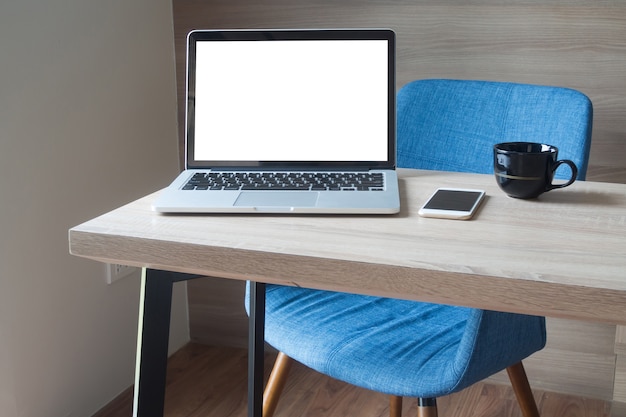 hölzerne Tabelle mit leerem Kopienraumlaptop im Arbeitsraum.