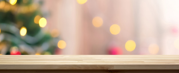 Hölzerne Tischplatte auf buntem bokeh Hintergrund vom dekorativen Licht auf Weihnachtsbaum