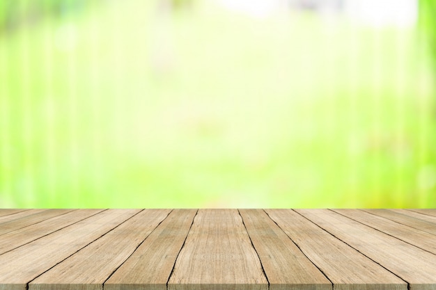 Hölzerne Tischplatte auf Naturgrün verwischte Hintergrund, für die Montage Ihrer Produkte