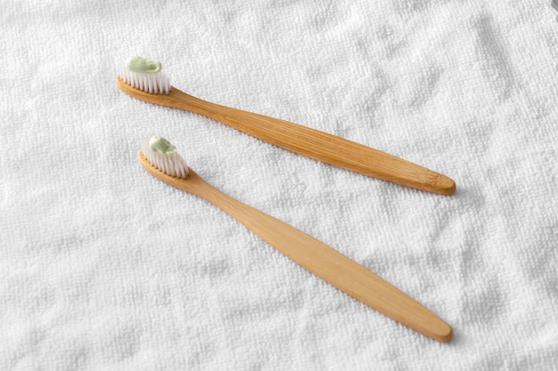 hölzerne Zahnbürste mit weißem Stoff auf weißem Hintergrund
