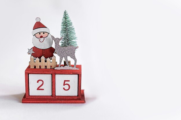 Hölzerner Adventskalender am 25. Dezember auf weißem Hintergrund mit Weihnachtsmann, Rentier. Kopieren Sie Platz für Text