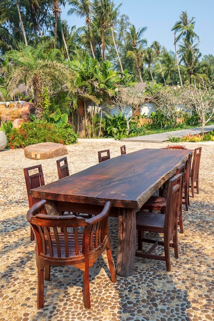 Hölzerner Cafétisch und Stühle an einem tropischen Strand Thailand Urlaubskonzept