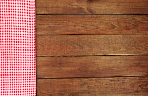 Hölzerner Hintergrund mit roter und weißer karierter Gewebegrenze.