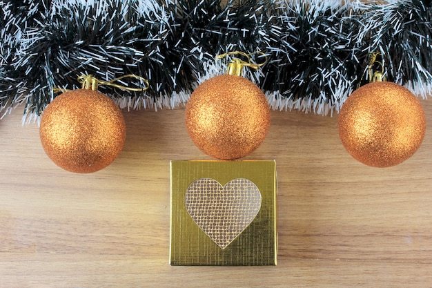 Hölzerner Hintergrund, Weihnachtsdekoration mit Bällen und Geschenke, dekorative Baumaste