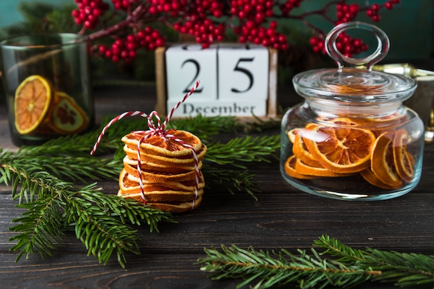 Hölzerner Kalender mit Datum am 25. Dezember, Weihnachtsdekor, orange Chips auf Holz