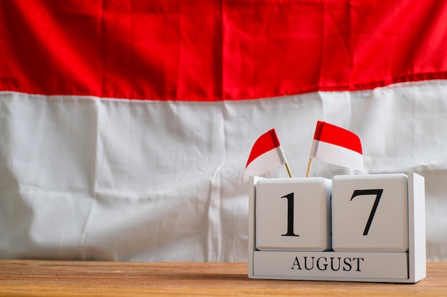 Hölzerner Kalender vom 17. August mit Miniaturflaggen von Indonesien. Indonesiens Unabhängigkeitstag, Nation Holiday Day und fröhliche Feierkonzepte