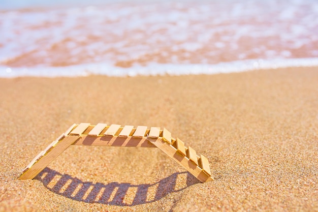 Hölzerner Liegestuhl an einem tropischen Sandstrand