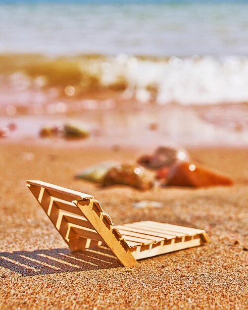 Hölzerner Liegestuhl an einem tropischen Sandstrand