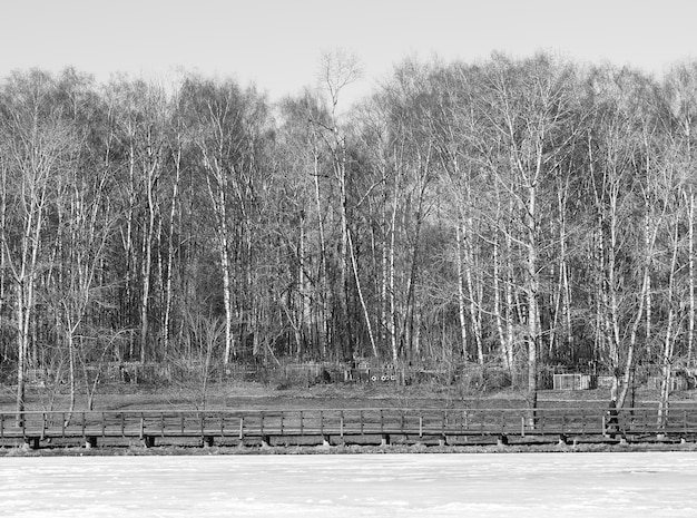 Hölzerner Pier auf gefrorenem Flusshintergrund