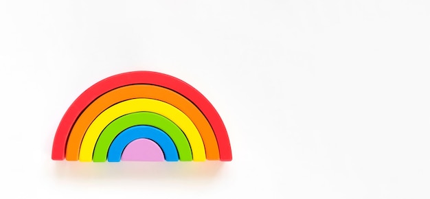 Hölzerner Regenbogen getrennt auf weißem Hintergrund. Regenbogen-Spielzeug-Puzzle. LGBT-Flagge Gay Pride Community gleich