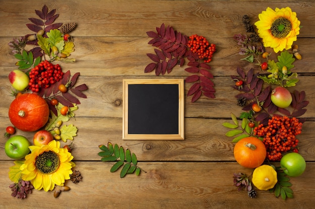 Hölzernes quadratisches Bilderrahmenmodell mit Sonnenblumen, Kürbissen und Herbstblättern. Rustikales Mock-up des leeren Rahmens für Präsentationsdesign. Vorlagenrahmen für moderne Kunst.