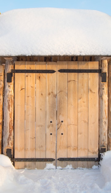 Hölzernes Tor im Zaun an einem sonnigen Wintertag