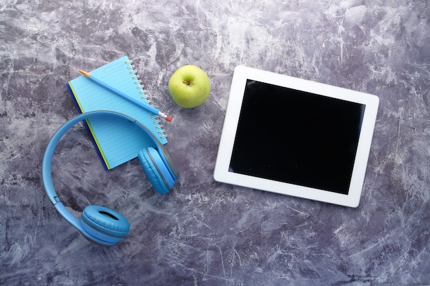 Hörbuchkonzept. Kopfhörer und digitales Tablet auf dem Tisch.