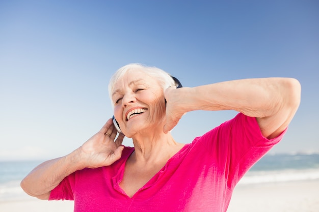 Hörende Musik der älteren Frau mit Kopfhörer