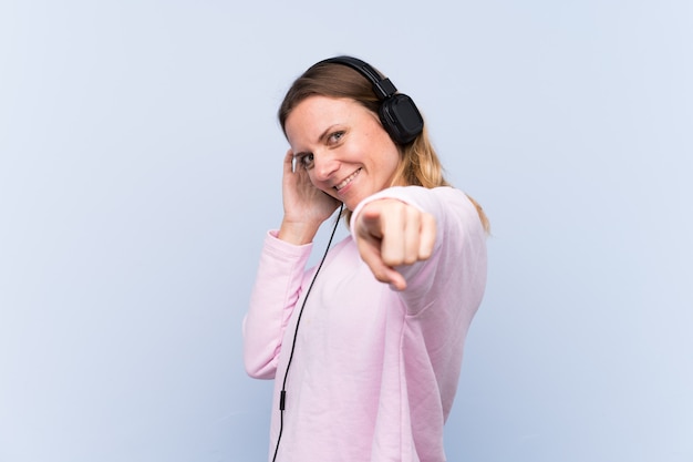 Hörende Musik der Frau über lokalisierter blauer Wand