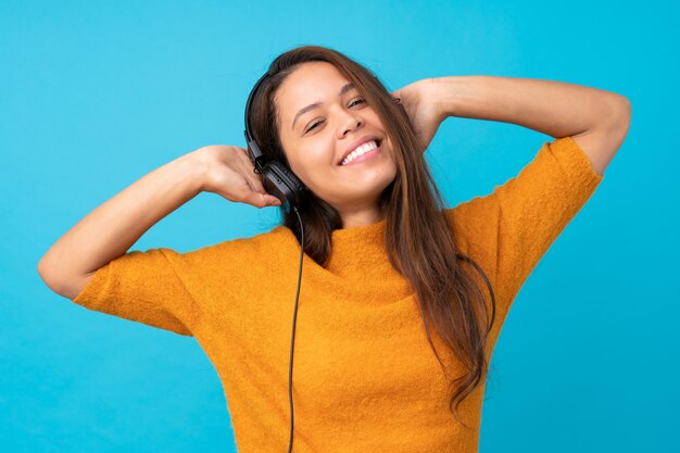 Hörende Musik der jungen Frau über lokalisierter Wand