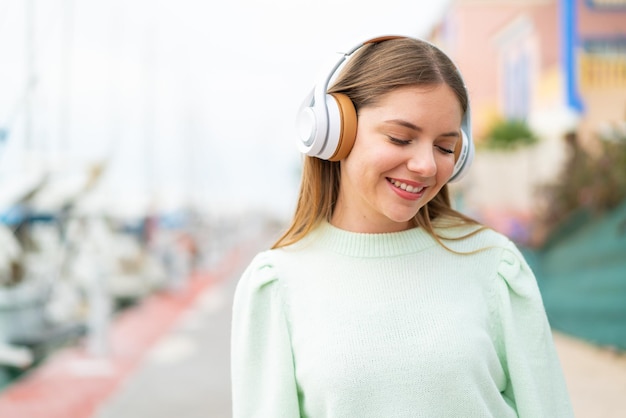 Hörende Musik der jungen hübschen blonden Frau