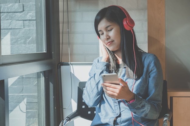 Foto hörende musik des hübschen mädchens mit ihren kopfhörern